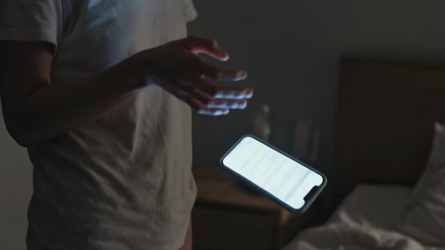 Femme laissant tomber son smartphone sur un lit dans l&rsquo;obscurit&eacute;, lumi&egrave;re douce de l&rsquo;&eacute;cran sur un visage &eacute;puis&eacute;, geste lent en ambiance nocturne minimaliste