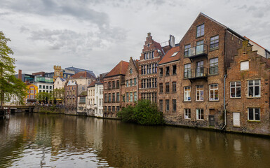Naklejka premium View of a row of well-preserved historic guild houses and traditional Flemish architecture lining the Leie river in the heart of Ghent, Belgium.