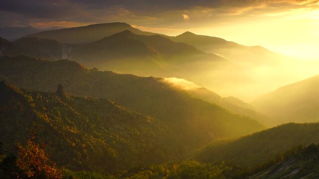 のぞき直下から望む御飯岳などの山並みと紅葉の樹林と夕日