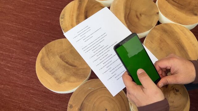 Hombre escaneando documento con m&oacute;vil pantalla verde