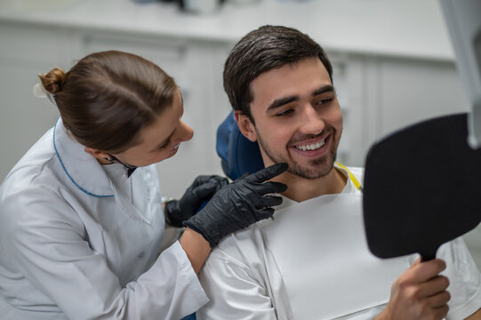 Male patient looking in mirror after dental treatment