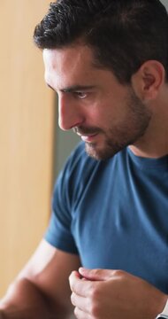 Man feeling eye itch, inspecting face with round mirror at sink wearing navy shirt, smartwatch