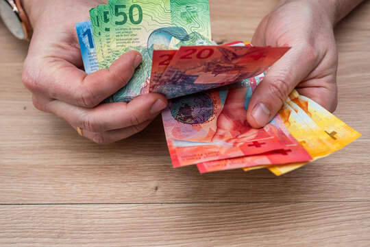 Close up of Man Hands Counting Swiss Franc Banknotes for Personal Savings and Wealth Management