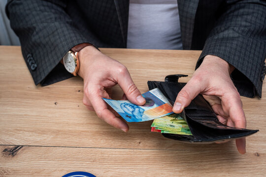 Businessman Hands Holding Black Leather Wallet with Swiss Franc Banknotes for Personal Expenses