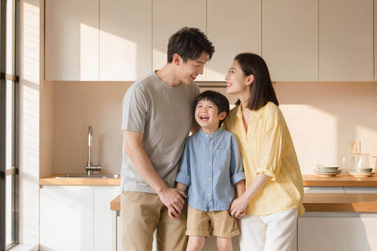 Famille heureuse dans une cuisine lumineuse, parents et enfant partageant un moment complice, lumi&egrave;re naturelle et ambiance chaleureuse