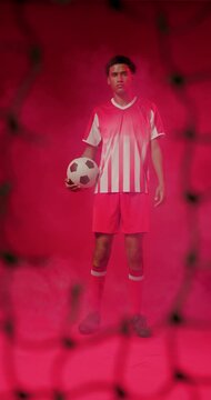 African male player in studio holding ball, shifting as fog-machine releasing haze with net, posing