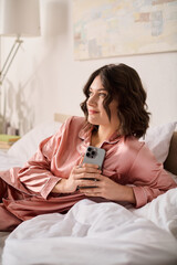 Beautiful woman enjoying a cozy moment at home while relaxing on her bed