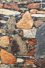 Fototapeta premium Rustic rubble stone wall in orange and grey front view portrait