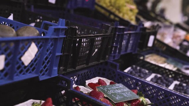 Obststand mit Erdbeeren, Blaubeeren und Trauben mit Sch&auml;rfenverlagerung auf frische Fr&uuml;chte im Stra&szlig;enverkauf