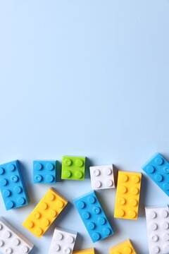 Construction toy. Colorful building blocks on light blue background, top view. Space for text