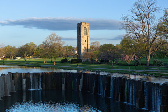Scenic early morning view of the waterfall at Culler Lake in Baker Park, Frederick, Maryland, with the historic Joseph Dill Baker Carillon in the background.