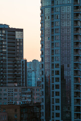 Fototapeta premium Serene layered perspective of urban apartment buildings under soft peach sky