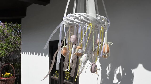 Hanging Easter egg decoration with ribbons on a village house.