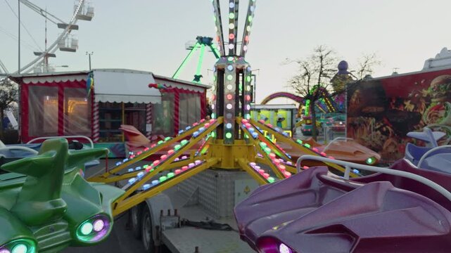 Colorful carousel with festive ambiance. Joyful children spinning on vibrant fairground ride. Children experiencing happiness on luminous amusement ride with neon details and lively atmosphere