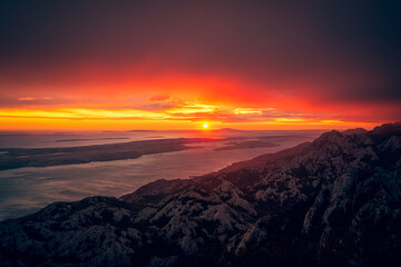 Obraz premium Vibrant sunset over mountains and sea horizon