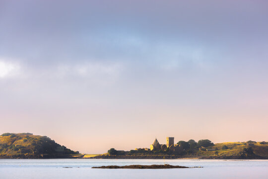 Idyllic sunrise or sunset view of the historic Incholm Abbey on the Firth of Forth as seen from Aberdour, Fife, Scotland, UK.