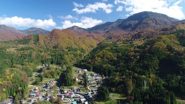 紅葉の中津川渓谷と小赤沢集落と槍ノ塔と苗場山などの山並み