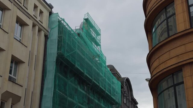 Restoration supports on old structure. Temporary frameworks supporting heritage building repairs. Archive image illustrating layered support systems during restoration of historic building facades