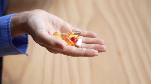 Woman holding various vitamin supplements and pills