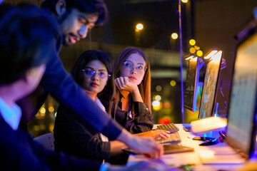 Fototapeta premium Focused cybersecurity specialist analyzing real time threat intelligence on multiple monitors. Diverse IT squad managing zero trust network and cloud native security in a glowing tech command center.