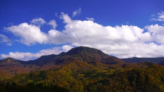 紅葉の槍ノ塔と苗場山などの山並みと流れる雲