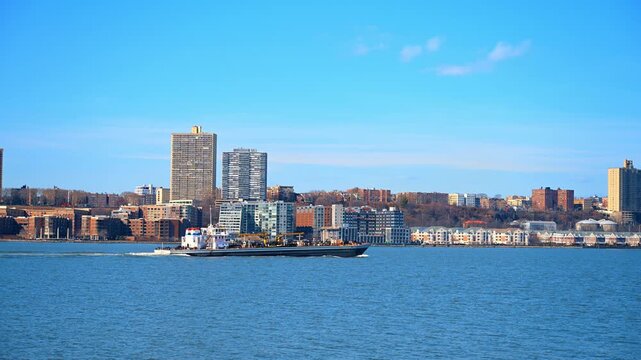 Large ship with loading cranes moves slowly by the waterscape. A vessel is heading to the port of New York City, USA at daytime.