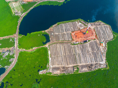 Aerial view of patterns of brick factories and rows of drying bricks contrasting against the lush green surroundings, Dhaka, Dhaka Division, Bangladesh.