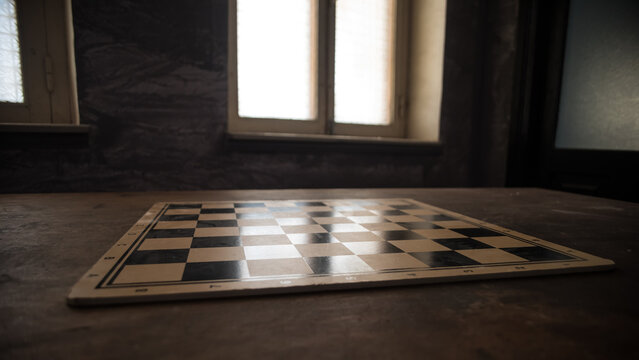 Chess board game concept of business ideas and competition. Empty chessboard on wooden table. Dark background.
