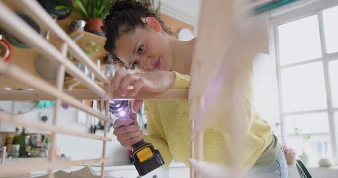 Young Adult Woman Assembling a piece of flat pack furniture at home