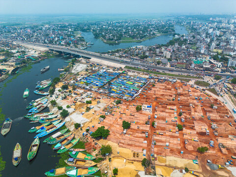 Aerial view of the contrasting textures of boats on the Buriganga River meeting the bustling markets and brickyards, Dhaka, Dhaka Division, Bangladesh.