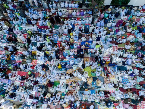 Aerial view of a large gathering of people praying in neat rows, their white clothing creating a serene pattern from above, Charmonai, Barisal Division, Bangladesh.