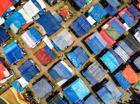 Aerial view of a vibrant tapestry of colorful tents creating a patchwork effect across the landscape, Charmonai, Barisal Division, Bangladesh.