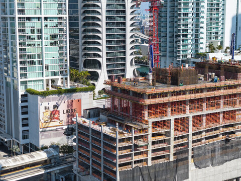 Aerial view of the towering cityscape with ongoing construction projects juxtaposed against modern architecture, a dynamic blend of progress and urban life, Miami, Florida, USA.