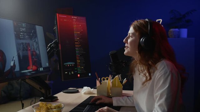 Side view of young Caucasian woman interacting with subscribers via chat while playing cooperative videogame