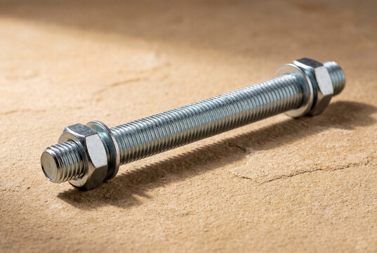 Silver Threaded Bolt with Hex Nuts and Washers on Stone Surface