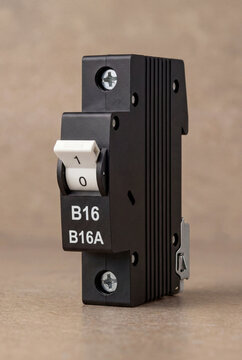 Black Miniature Circuit Breaker Switch for Electrical Protection on Tan Surface