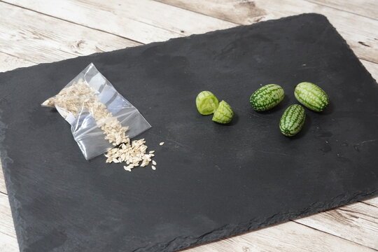 Cucamelon seeds and fresh fruits on slate