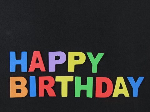 Multicolored eva foam letters form the expression "Happy Birthday" on black background. Happy birthday sign.