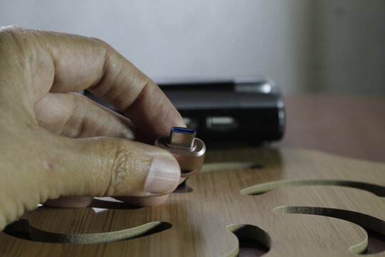 Lector de memoria sujetado por una mano con un fondo desenfocado.