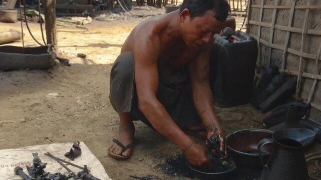 Myanmar oil worker cleaning mechanical components in an unregulated oil field