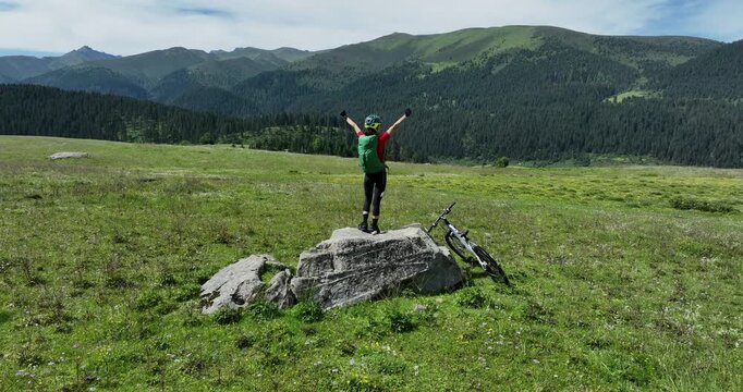 Aerial footage of woman riding mountain bike on beautiful forest mountain trail