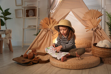 Little girl with drawing of map near wigwam at home. Space for text © New Africa