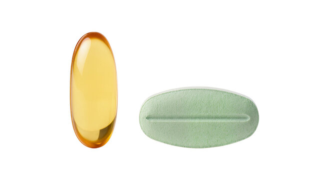 Amber oval softgel capsule and green oval tablet with score, isolated on transparent background