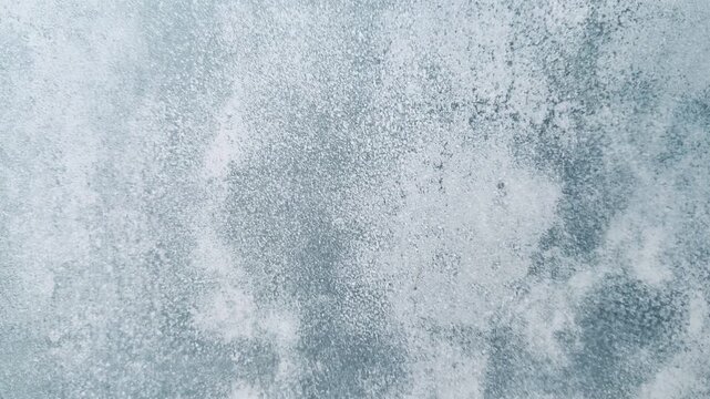 Close-up plaster texture cottage wall blue-gray mottled surface, granular finish with speckled patina and subtle weathered detail.