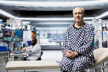 Portrait of old man starting a clinical trial in research lab to test new drug, sitting on a bed...