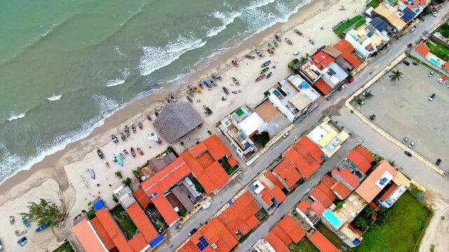 Top Down Aerial View of Colorful Fishing Boats on Beach Next to Coastal Town in Northeast Brazil