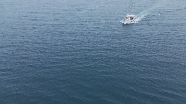 Aerial drone view of a traditional fishing boat  in open sea, Greece. Scenic  Mediterranean atmosphere, perfect for travel, lifestyle and maritime concepts.