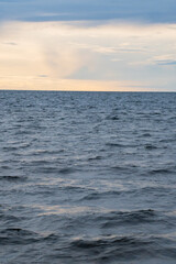 Obraz premium Vertical abstract view of blue water waves and sea horizon. Minimalist natural background with copy space.