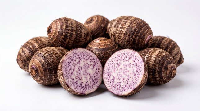 Collection of Raw Taro Corms on White Background with One Halved Taro