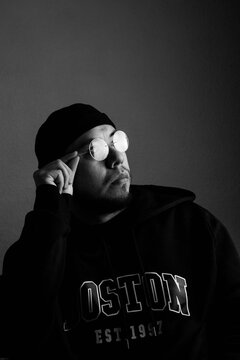black and white portrait of a hispanic man with a hat and glasses